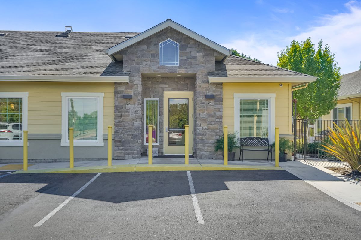 A suburban house with a modern facade and an adjacent parking lot.