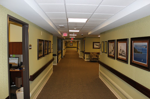 A well-lit and decorated hallway featuring framed artwork along the walls.
