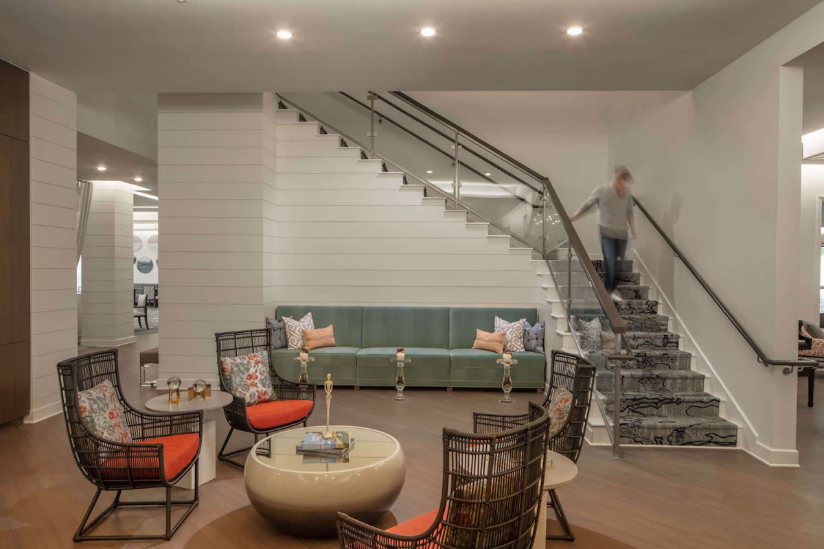 A modern living room featuring a staircase, comfortable seating, and contemporary decor.