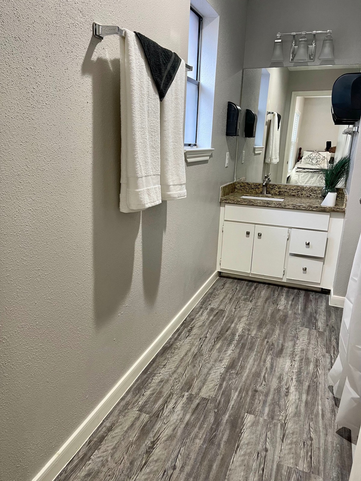 A modern bathroom with a sink, mirror, and neatly hung towels.