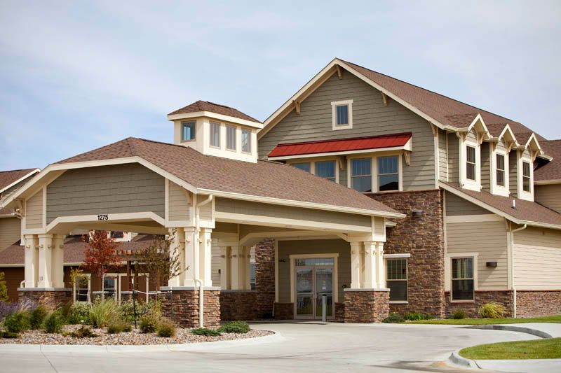 A modern residential building with a prominent entrance and peaked roof.