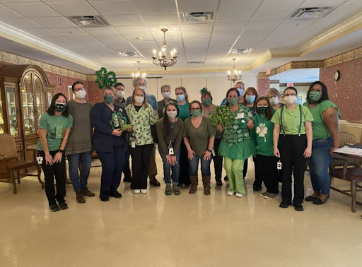 A festive gathering where everyone is dressed in green, celebrating together.