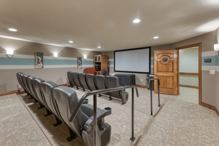 A cozy home theater with recliner seating and a large projector screen.