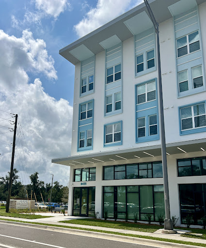 A modern commercial building showcasing contemporary architecture against a cloudy sky.