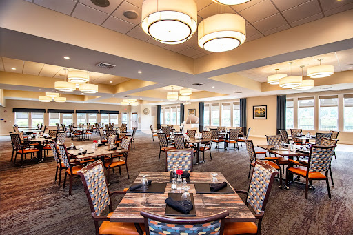 A spacious and elegant dining room featuring modern decor and ample seating.
