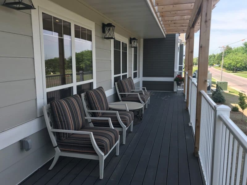 A cozy porch with chairs and a table, perfect for relaxation.