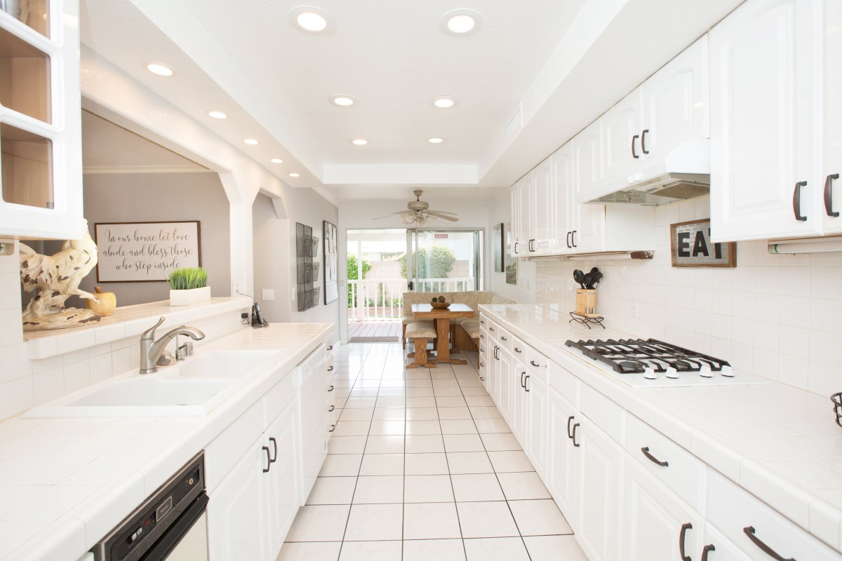 A bright and modern kitchen with white cabinets and tiled flooring.