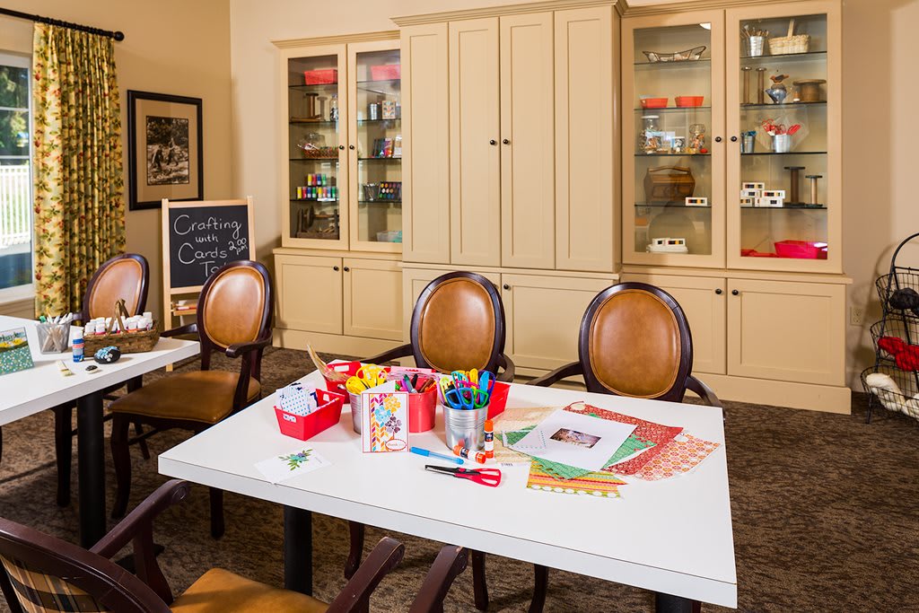 A well-organized craft room with a table set up for arts and crafts activities.