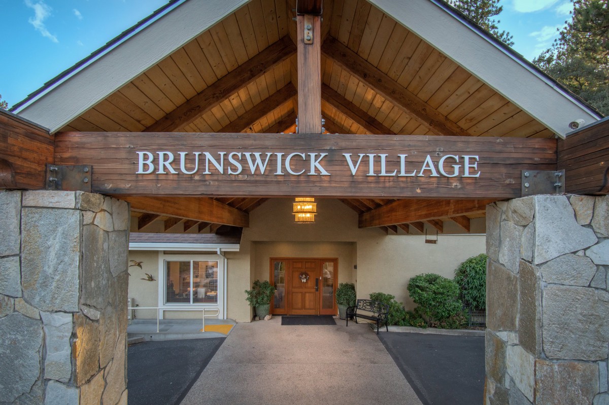 The entrance to Brunswick Village, featuring prominent wooden beams and signage.