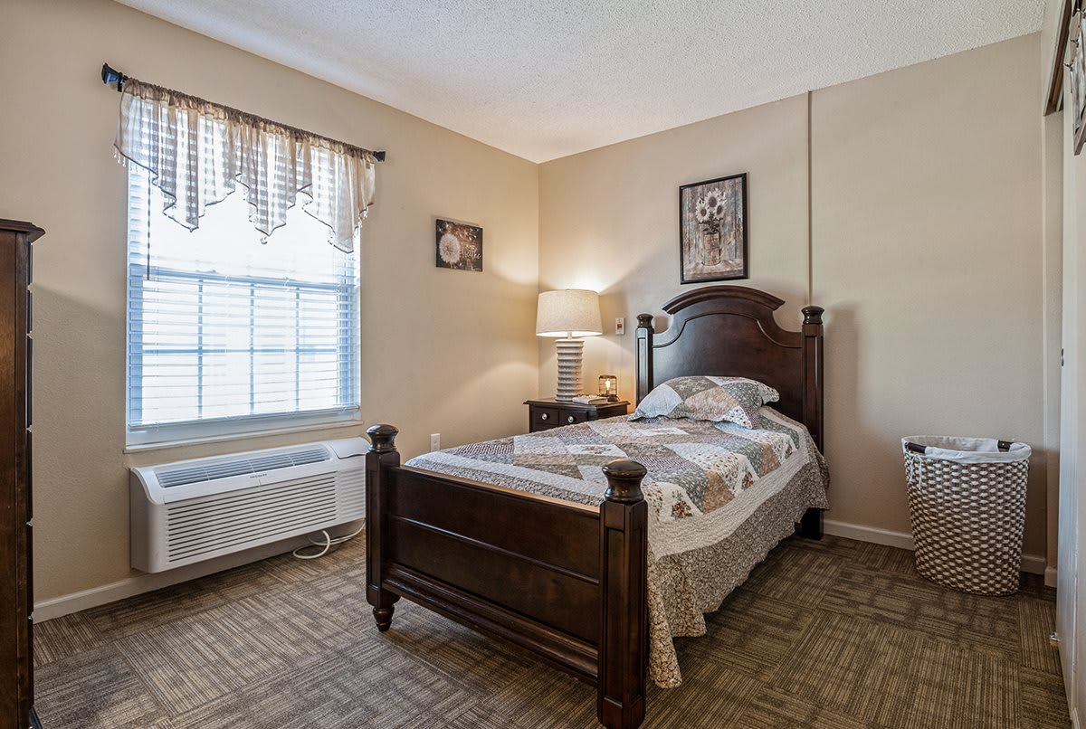 A cozy bedroom with a single bed and a lamp by the side.