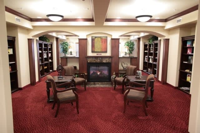 A cozy lounge area with bookshelves and a fireplace.