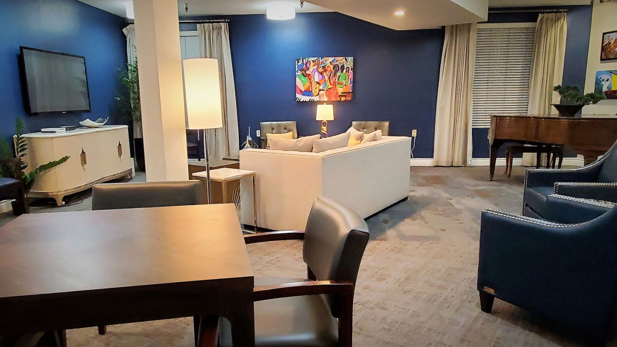 A modern living room with a cozy sofa, vibrant artwork, and elegant lighting.