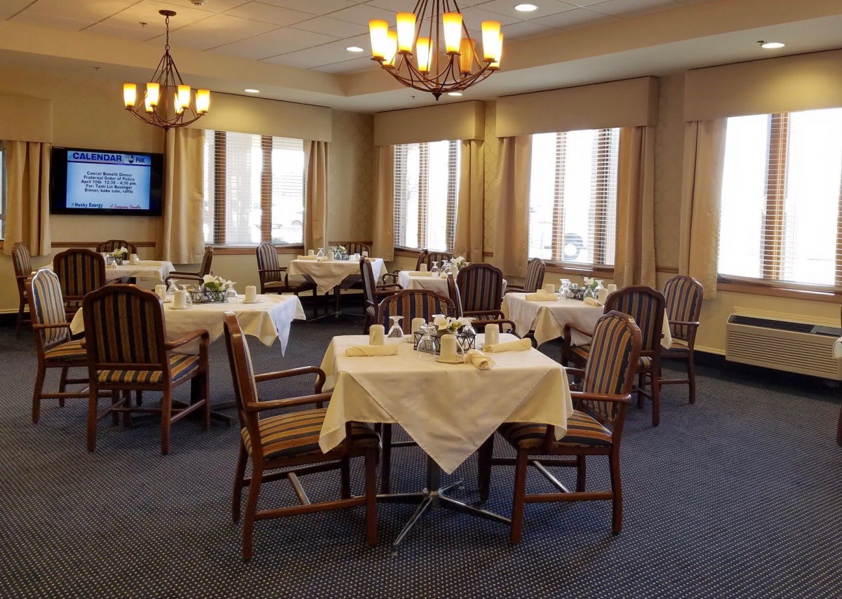 A well-set dining room with neatly arranged tables and elegant lighting.