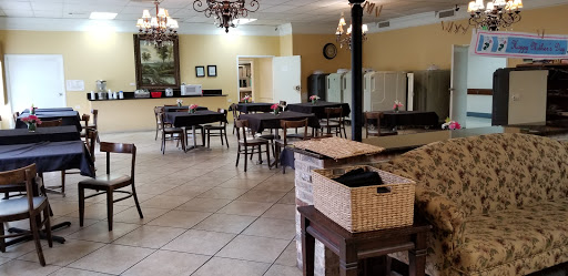 A spacious dining area featuring neatly arranged tables and chairs, complemented by elegant chandeliers.
