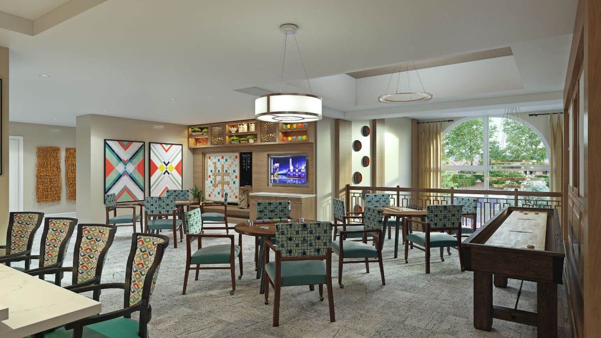 A modern dining area featuring stylish furniture, artwork on the walls, and a television.