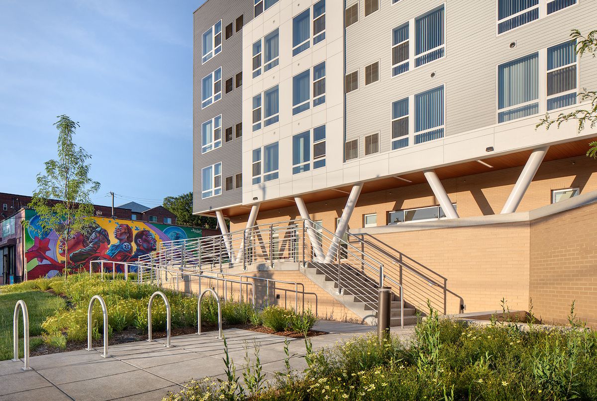 A modern apartment building with a colorful mural on its exterior wall.