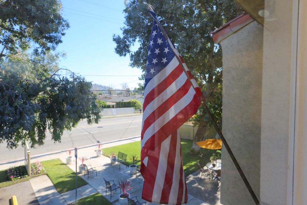An American flag waving outside a building on a sunny day.