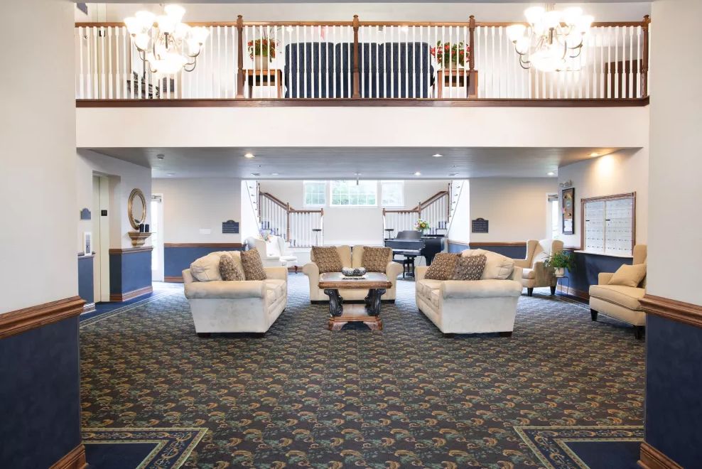 A spacious and elegantly designed lobby area with sofas and chandeliers.