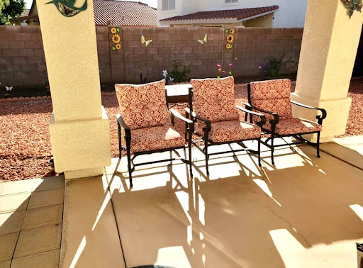 A cozy patio setup with three inviting chairs basking in the sunlight.