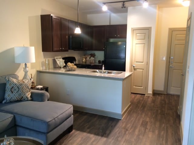 A modern apartment with an open kitchen and living area featuring contemporary furniture.