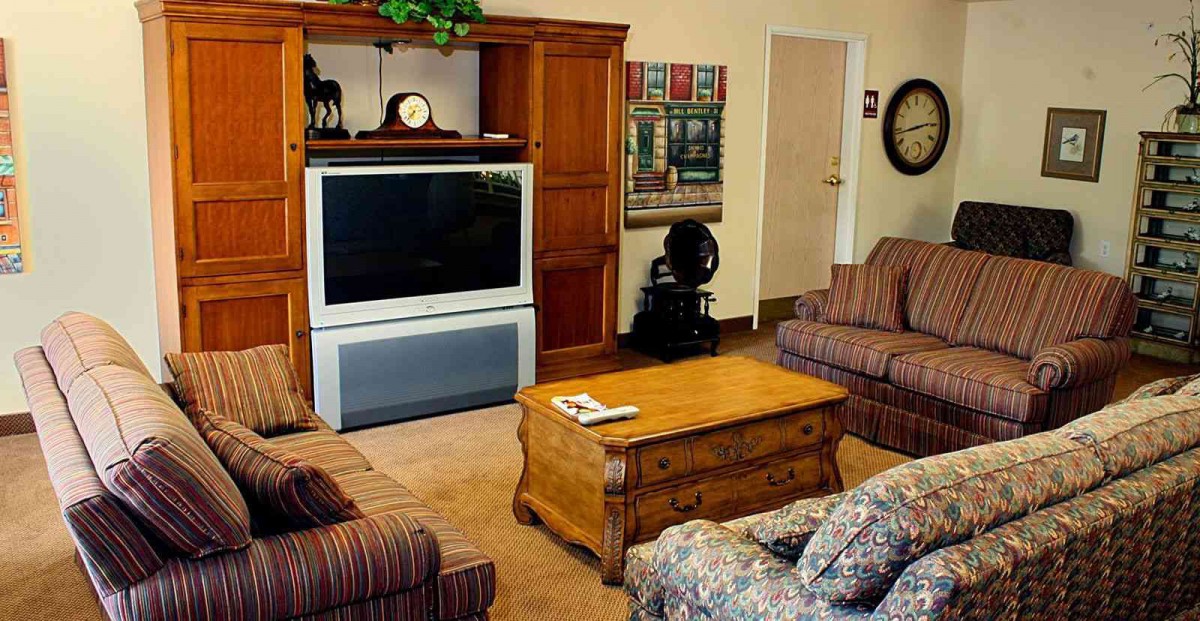 A cozy living room with classic furniture and a large television.