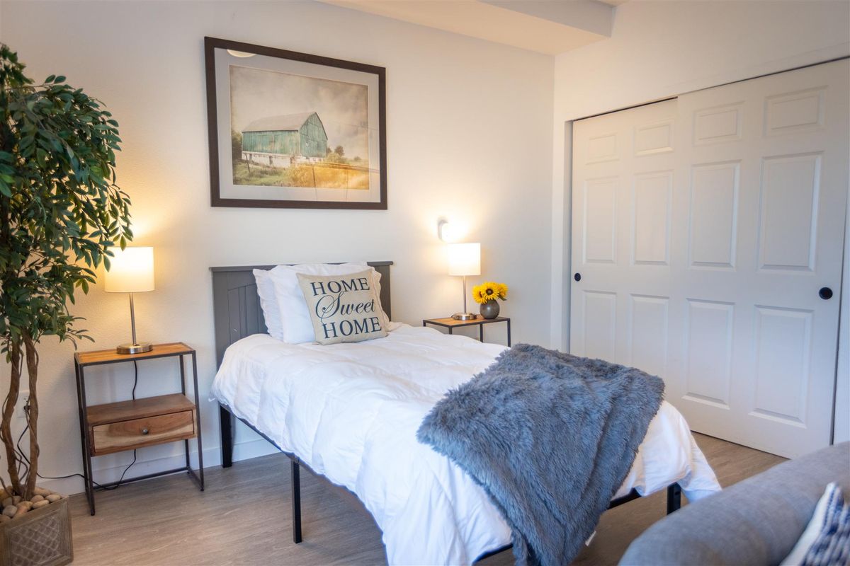 A cozy, minimalist bedroom with a single bed and decorative items.
