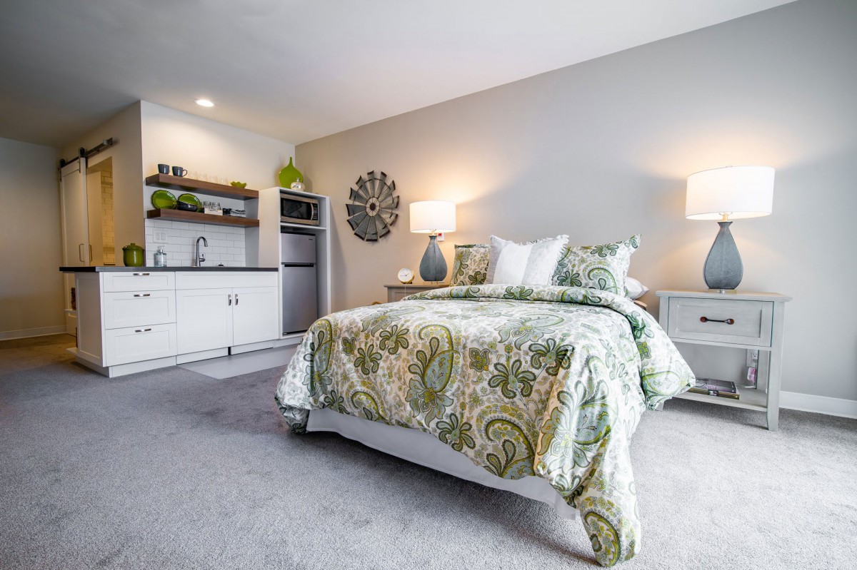 A modern and cozy bedroom with stylish bedding and ambient lighting.