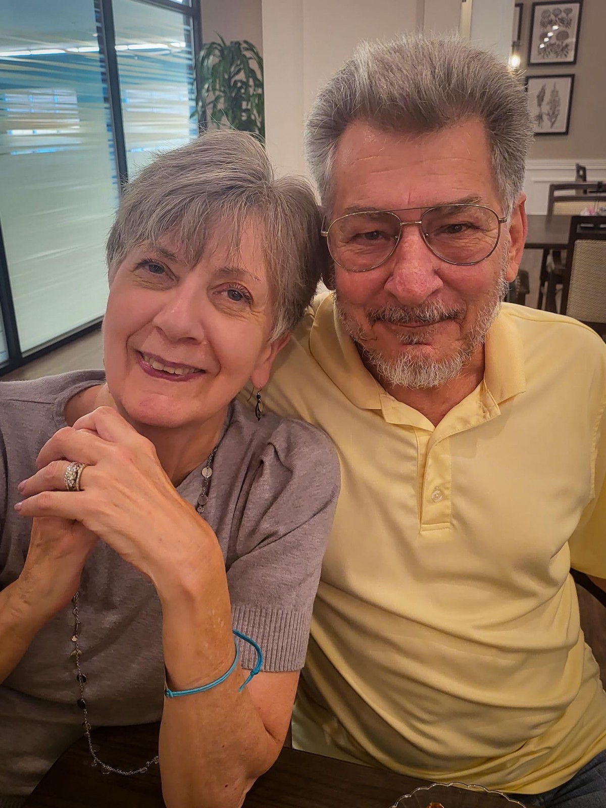 A smiling elderly couple enjoying their time together indoors.