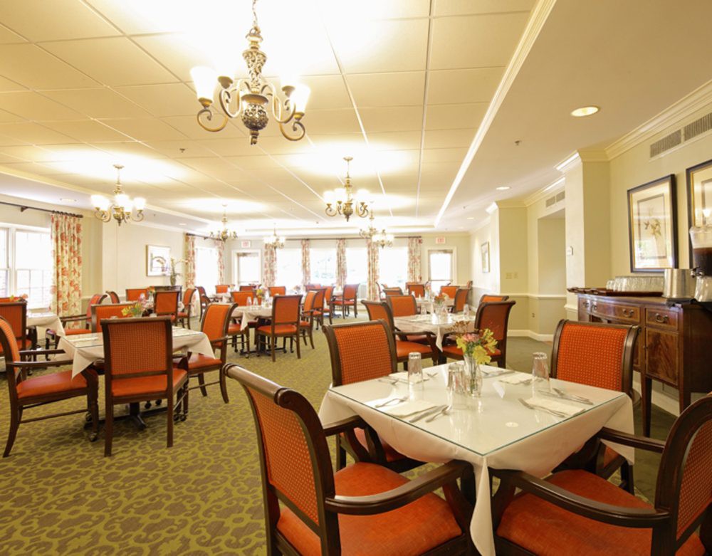 A well-lit and elegantly designed dining room with neatly arranged tables and chairs.