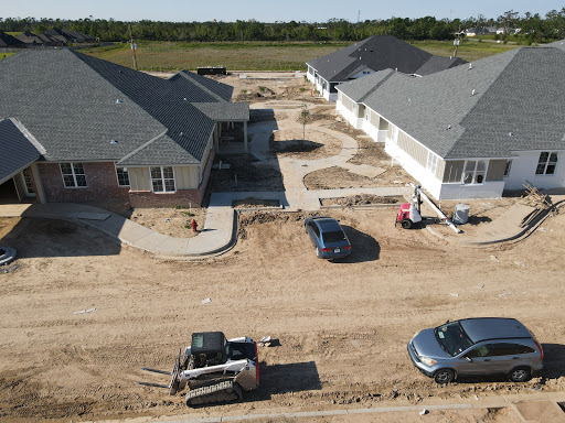 An aerial view of a residential construction site showing new homes and ongoing landscaping work.
