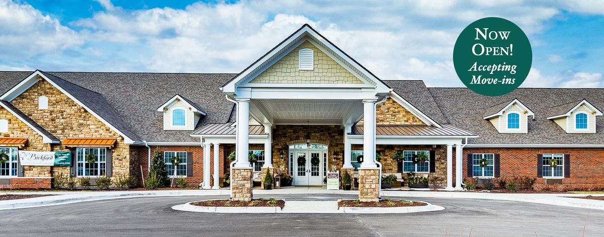 A building with a welcoming entrance featuring columns and brick and stone design.