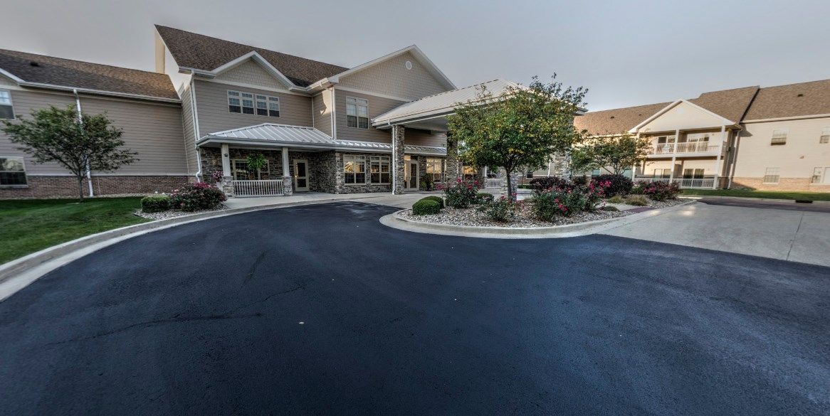 A residential building with a well-maintained driveway and landscaped entrance