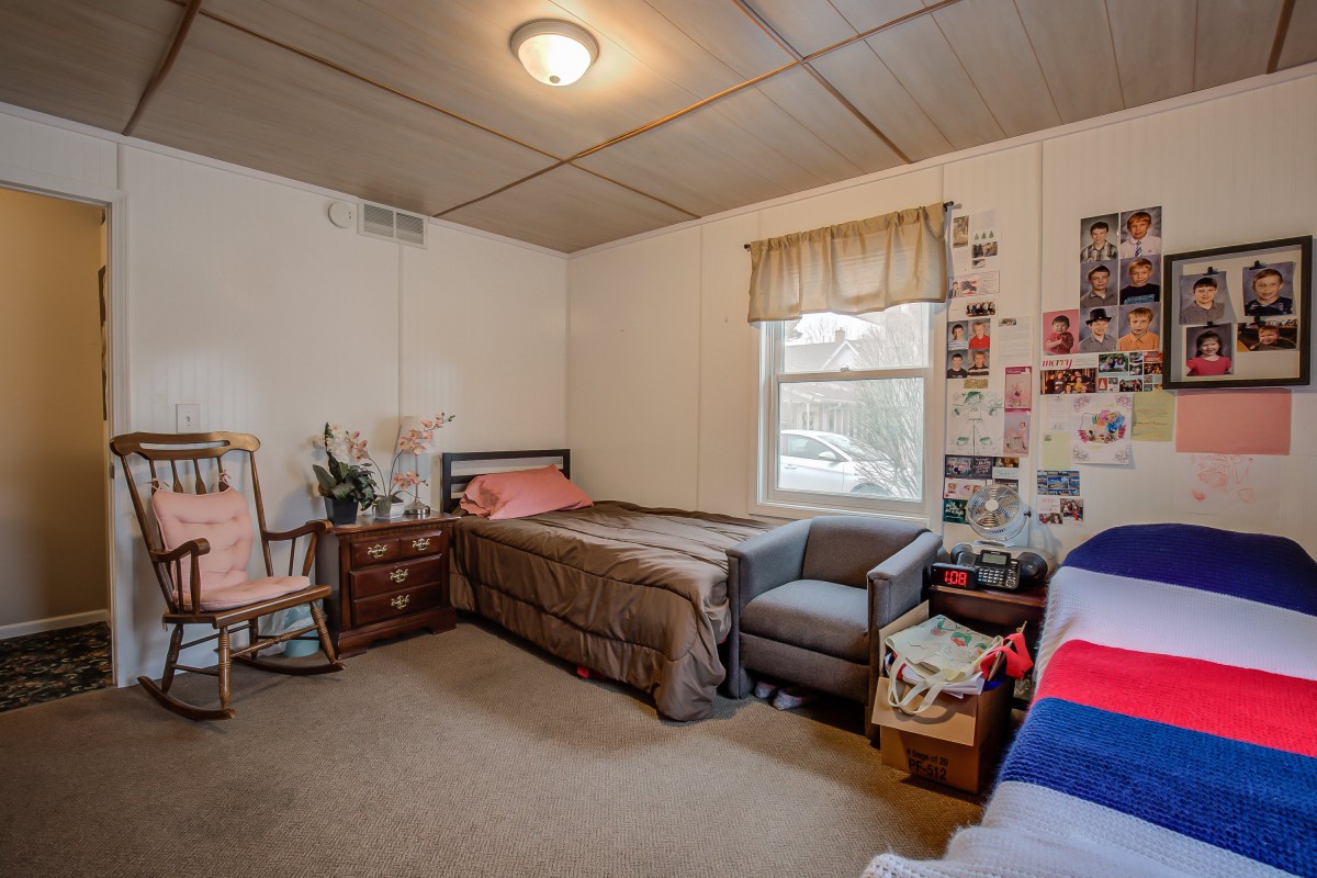 A cozy dorm room with a single bed, a desk, and a decorated wall.