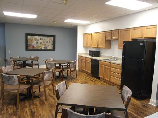 A spacious kitchen and dining area equipped with wooden tables, chairs, and various appliances.