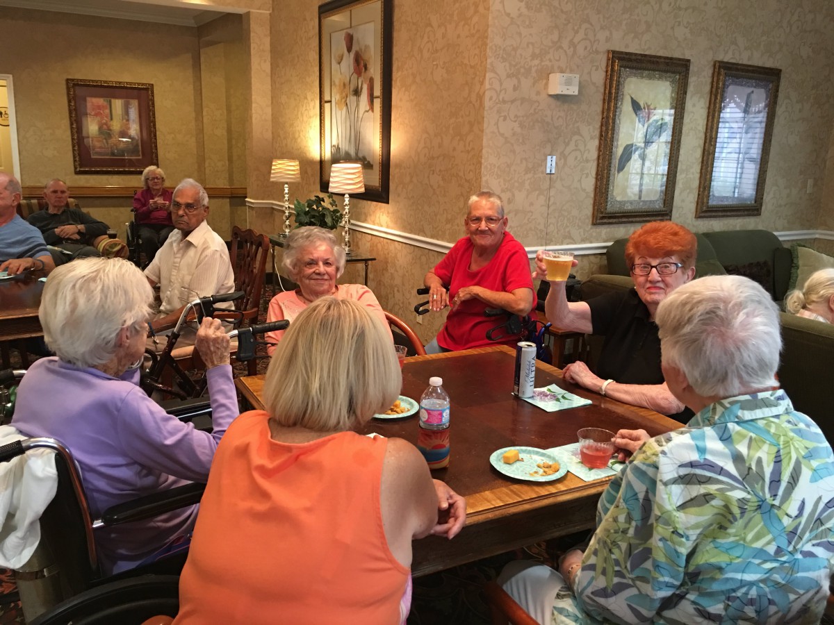 A group of seniors enjoying a meal and conversation together indoors.