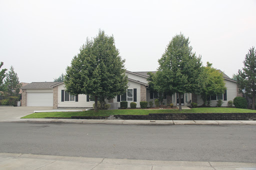 A charming suburban home surrounded by neatly trimmed trees.