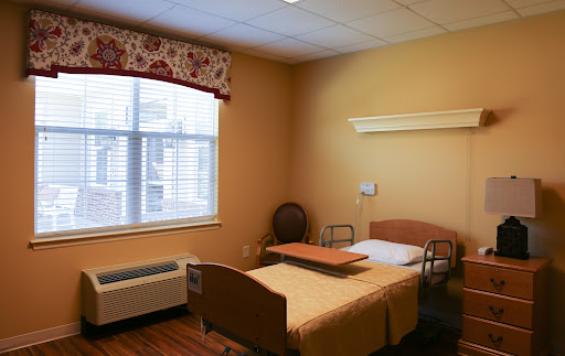 A comfortable and well-lit hospital room featuring a bed, window, and essential furnishings.