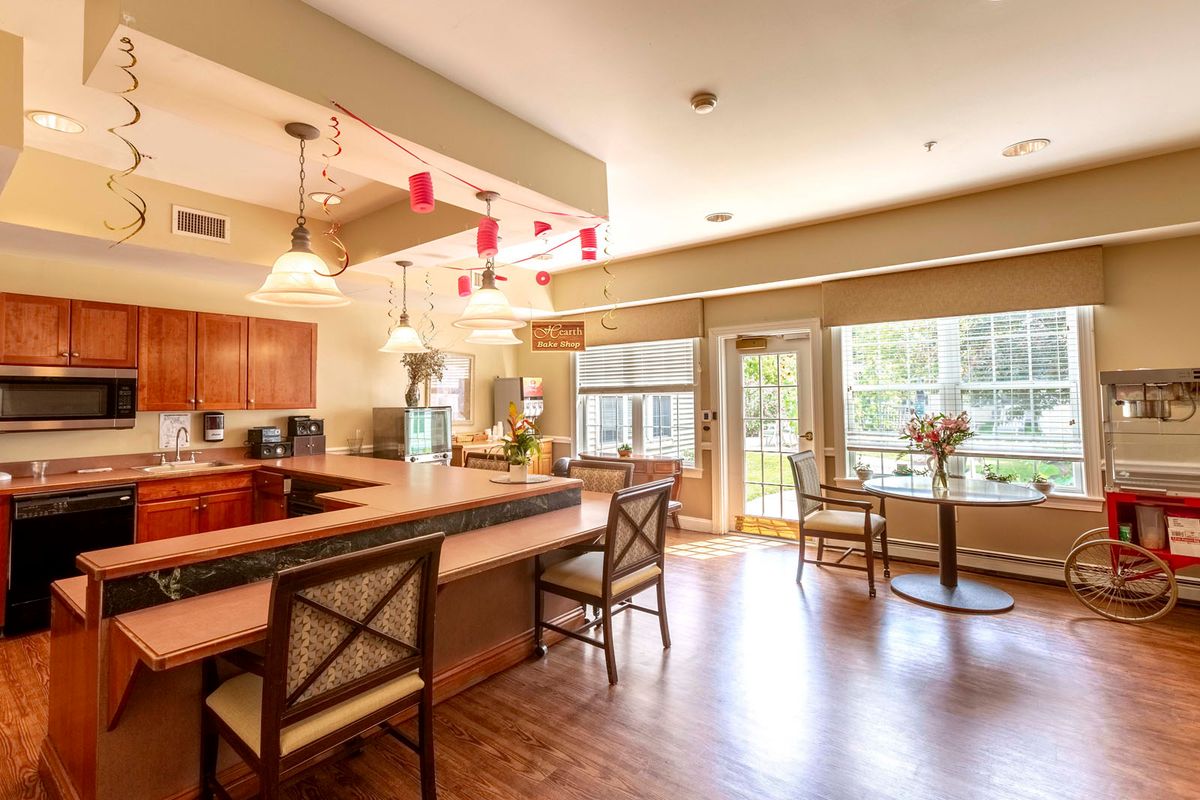 A spacious kitchen and dining area with a large countertop, bar stools, and plenty of natural light.