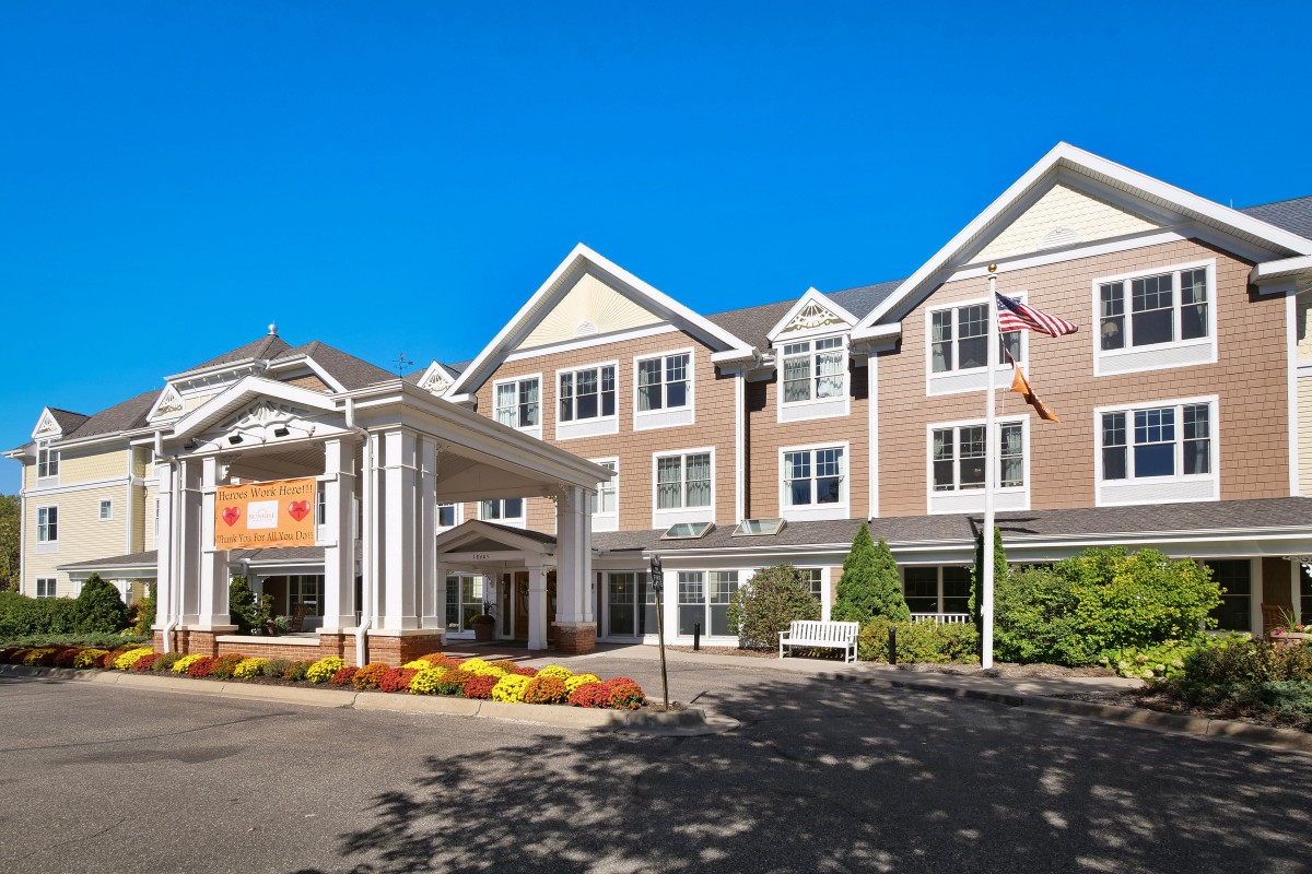 A three-story hotel building with a welcoming entrance and well-maintained landscaping.