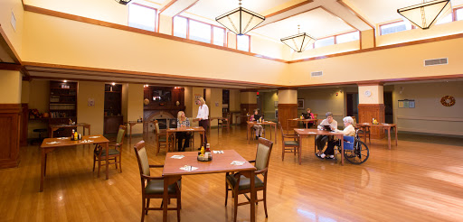 A spacious dining area with wooden flooring and ample natural light.