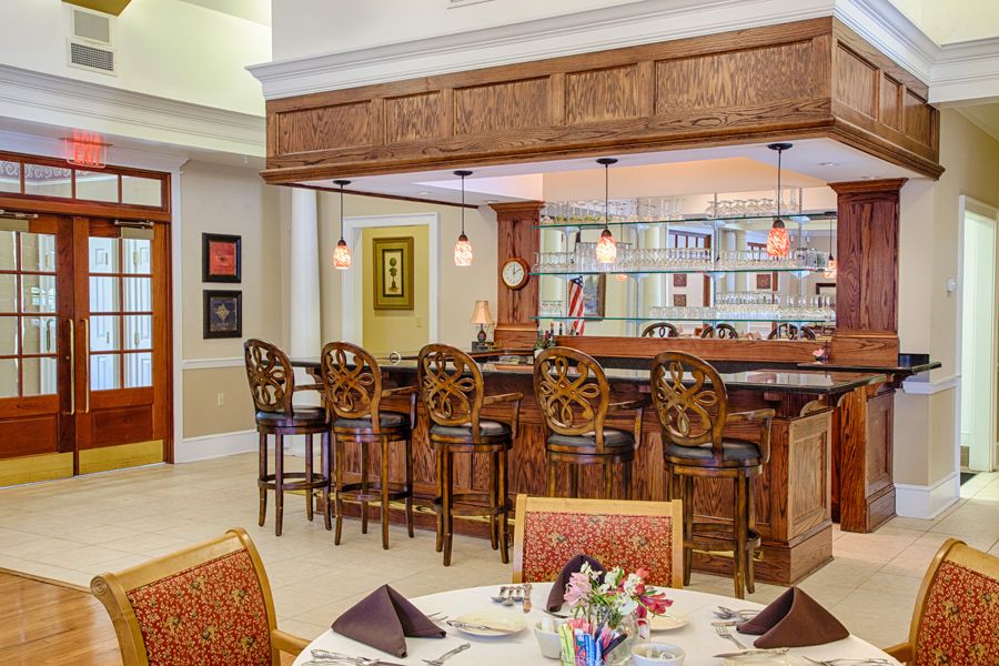 A cozy restaurant bar with elegant wooden decor and seating.