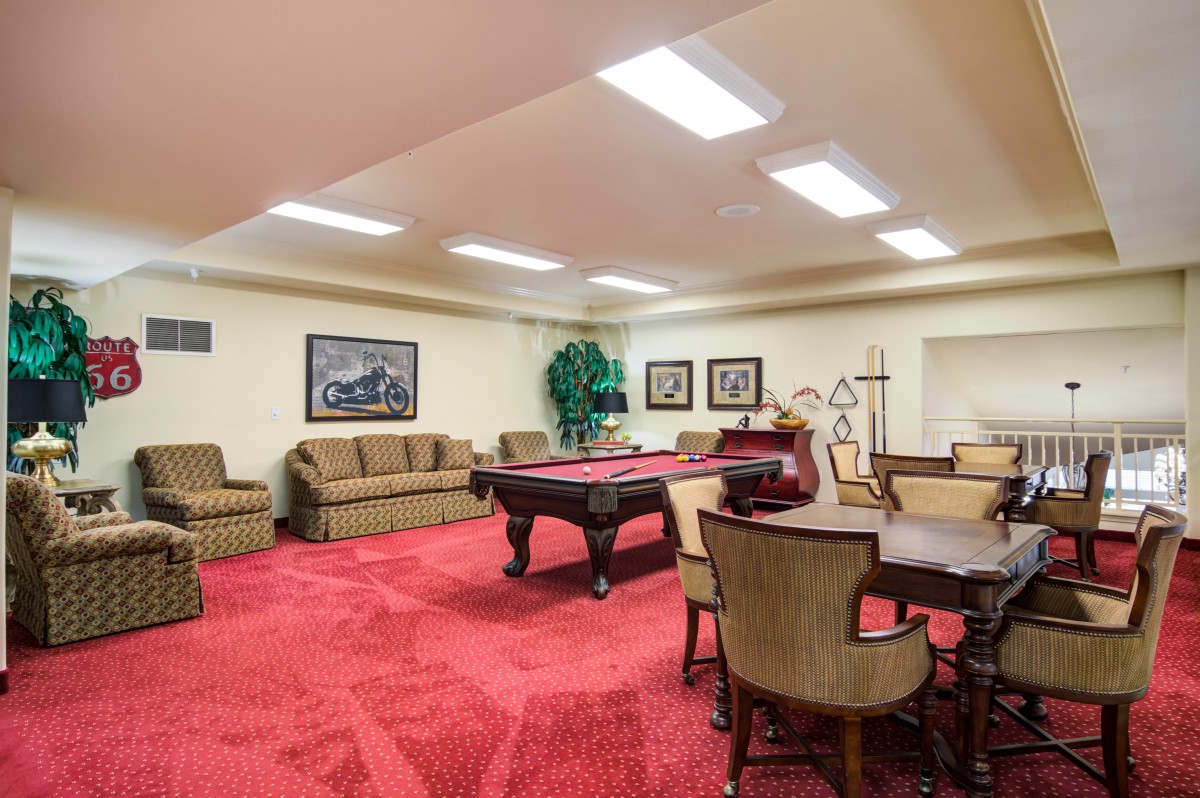 A cozy game room featuring a pool table, seating area, and elegant decor.