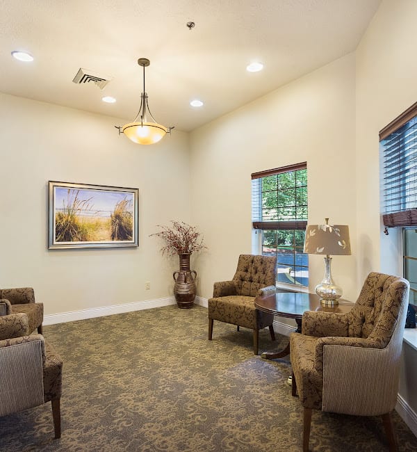 A cozy waiting room with comfortable chairs, warm lighting, and tasteful decor.