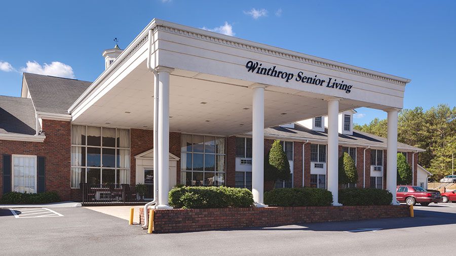 The entrance of Winthrop Senior Living facility on a sunny day.