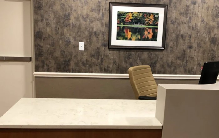 An empty office reception desk with a painting on the wall.