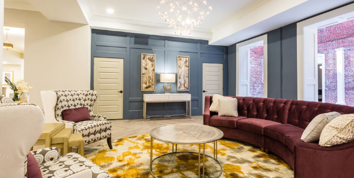 A modern living room with elegant furnishings and a vibrant yellow-patterned rug.