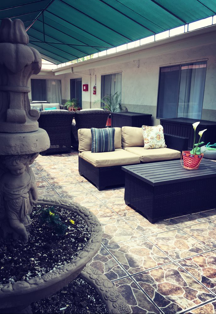 A cozy outdoor patio area with comfortable seating and a stylish coffee table, perfect for relaxing in a courtyard setting.