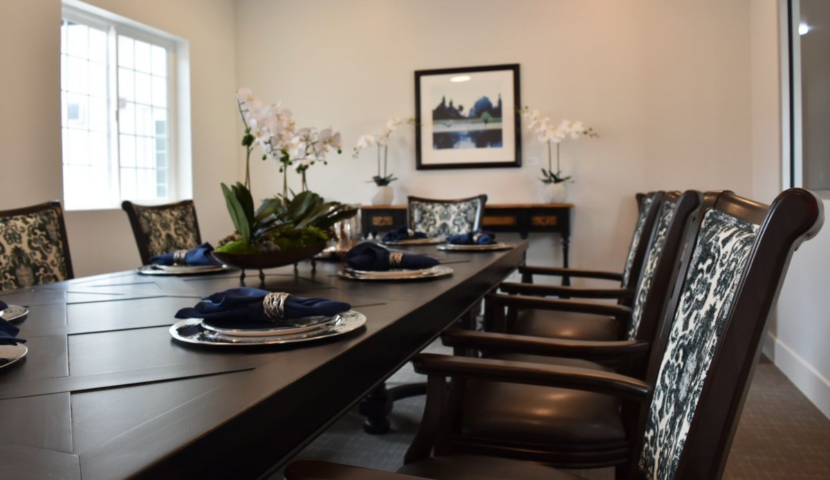 A stylish dining room with elegant table settings and decorative orchids.