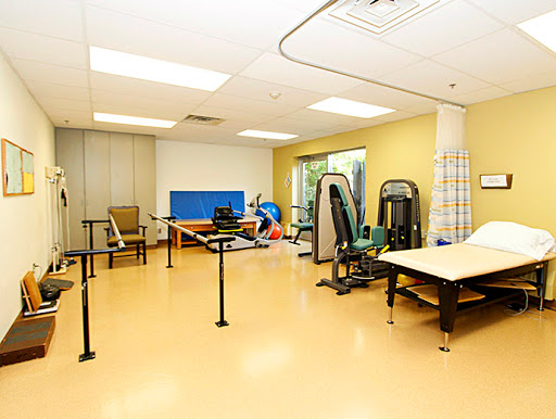 A spacious rehabilitation room filled with various exercise equipment designed for physical therapy.