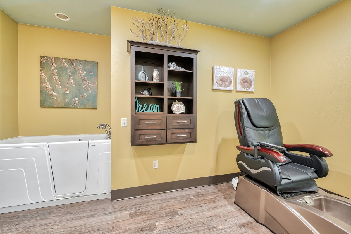 A cozy spa room featuring a massage chair and elegant decor.